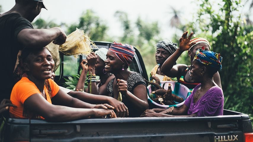 Afrikanere sidder i ladet bagpå bil